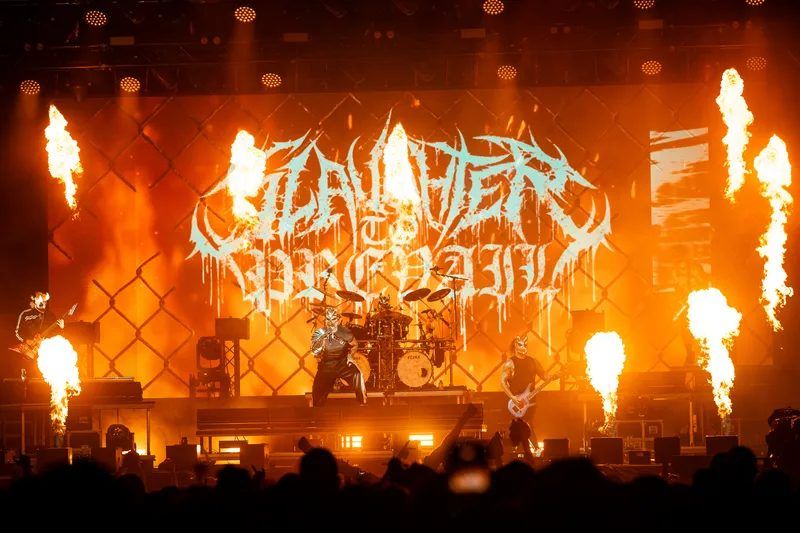 Slaughter to Prevail on stage in masks, flame jets either side of the band logo on the video wall
